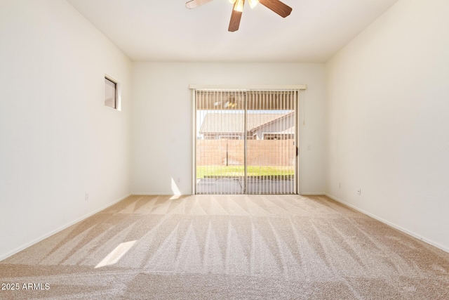 spare room with baseboards, ceiling fan, and carpet