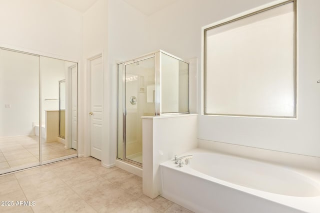 full bath featuring tile patterned floors, a bath, and a stall shower