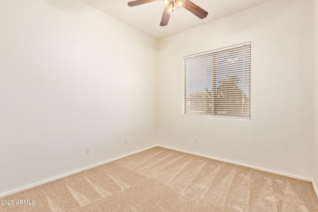 spare room featuring baseboards, ceiling fan, and carpet