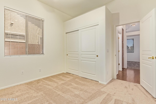 unfurnished bedroom with carpet floors, baseboards, and a closet