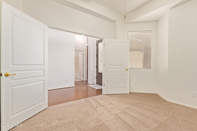 spare room featuring baseboards and carpet