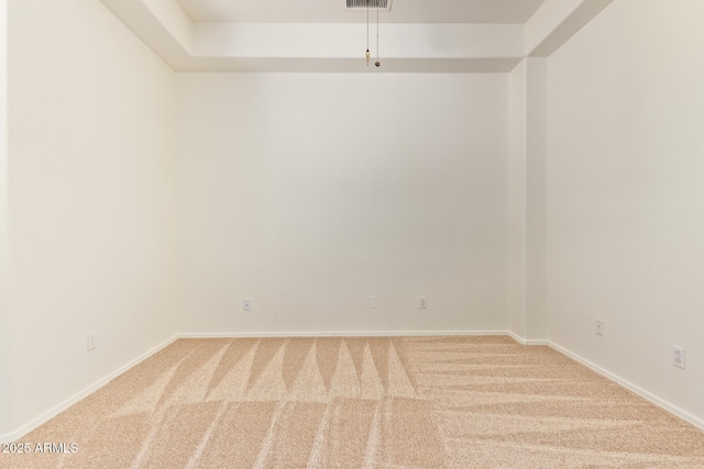 spare room featuring carpet floors, baseboards, and visible vents