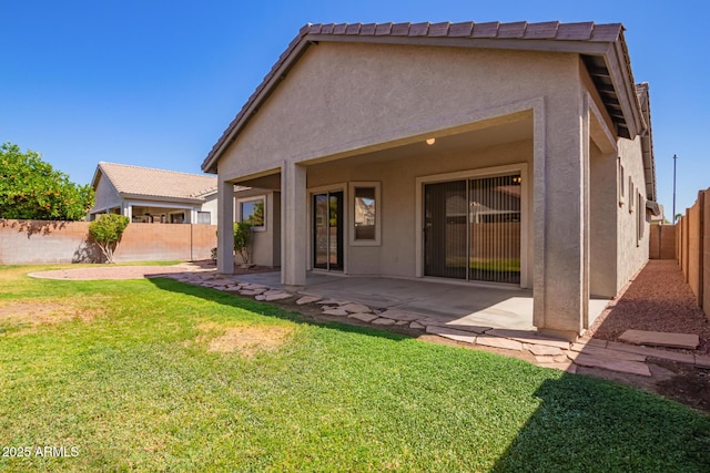 rear view of house with a yard, a patio, a fenced backyard, and stucco siding
