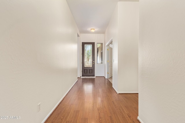 doorway to outside with baseboards and wood finished floors