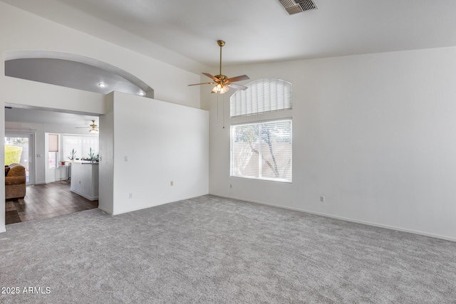 spare room with arched walkways, ceiling fan, carpet, and visible vents