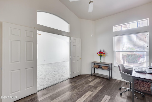 home office featuring dark carpet, a high ceiling, dark wood finished floors, and baseboards