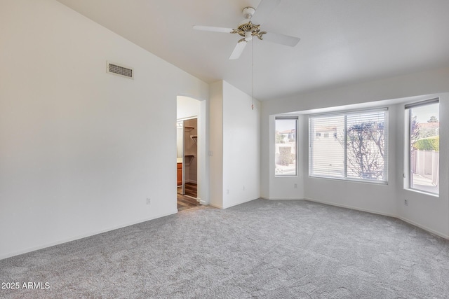 empty room with visible vents, arched walkways, lofted ceiling, ceiling fan, and carpet floors