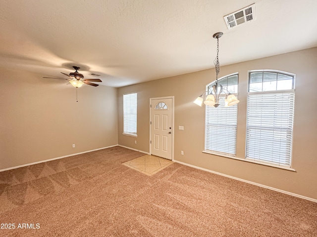 unfurnished room with ceiling fan with notable chandelier and carpet