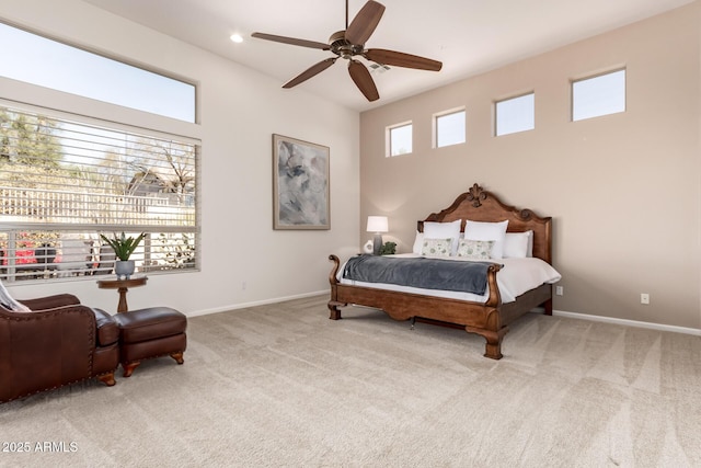 bedroom featuring light carpet, ceiling fan, and multiple windows