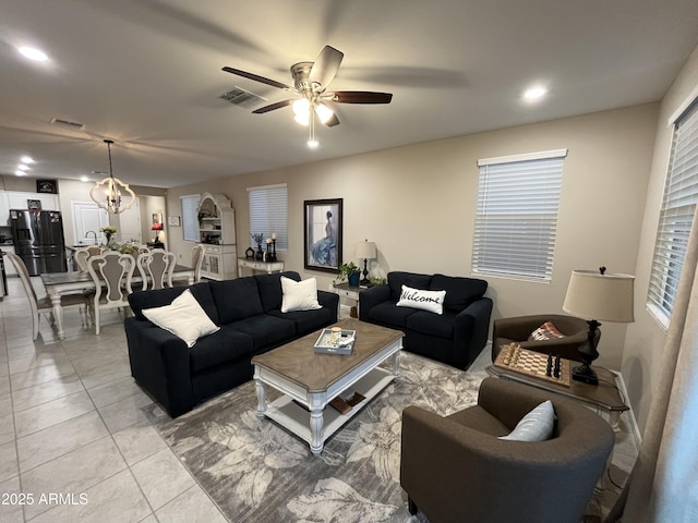 living room featuring ceiling fan with notable chandelier