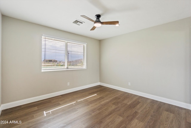 spare room with dark wood-type flooring and ceiling fan