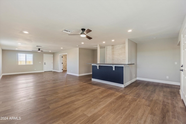 unfurnished living room with dark hardwood / wood-style floors and ceiling fan