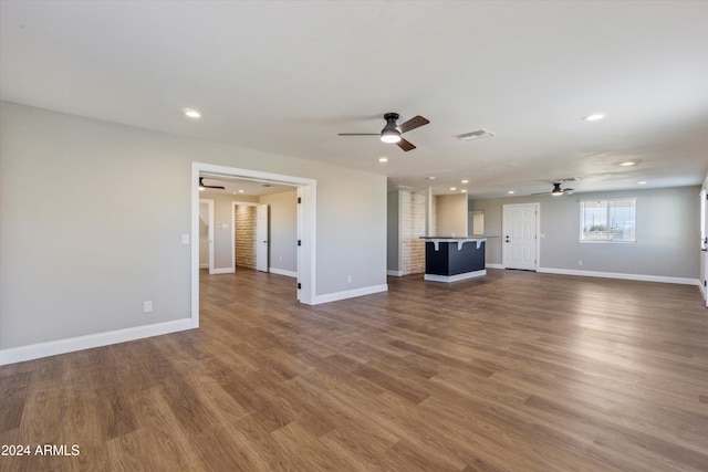 unfurnished living room with hardwood / wood-style floors and ceiling fan