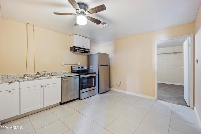 kitchen with sink, appliances with stainless steel finishes, white cabinetry, and light tile patterned floors