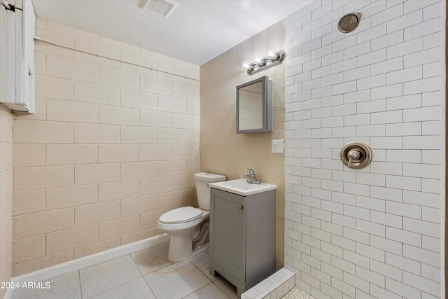 bathroom featuring toilet, walk in shower, sink, and tile patterned flooring