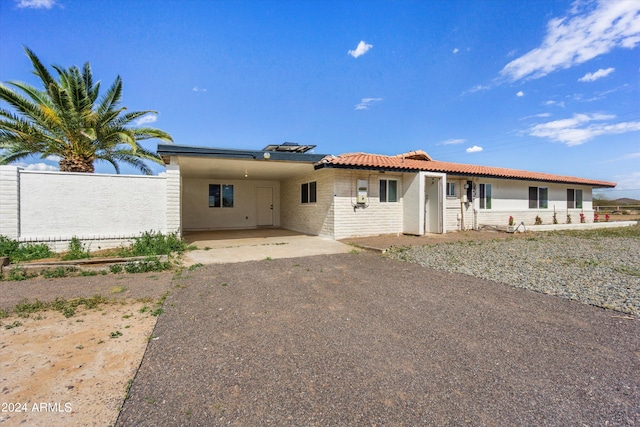 back of house featuring a carport