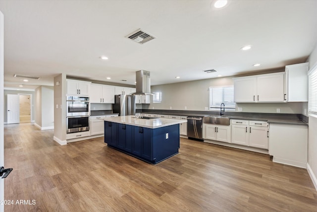 kitchen with light hardwood / wood-style flooring, white cabinetry, stainless steel appliances, and island range hood