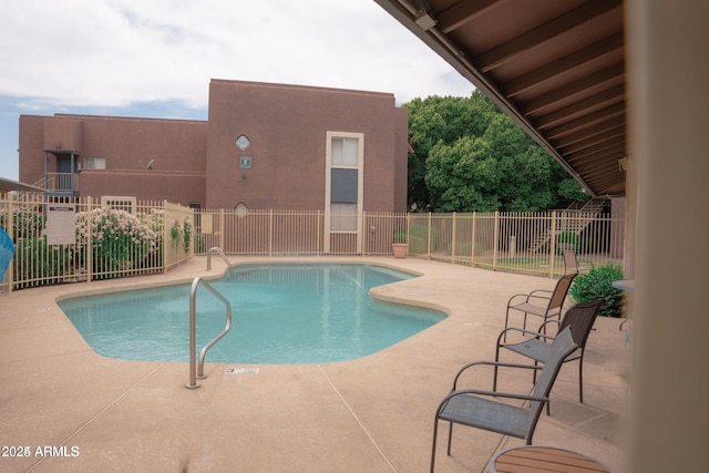 community pool with fence and a patio area