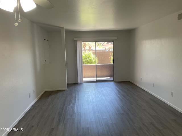 spare room with dark wood finished floors, baseboards, and a ceiling fan