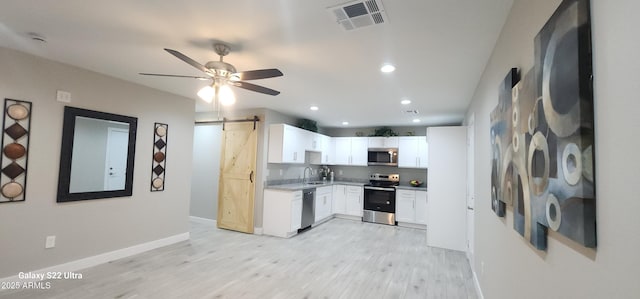 329 W Fairhaven Rd, Kearny, AZ 85137 - kitchen with stainless steel appliances, a sink, a barn door, light wood-style flooring, and recessed lighting