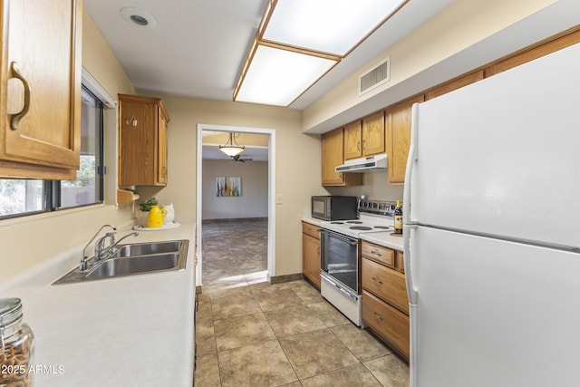 kitchen with white appliances, sink, and light tile patterned floors