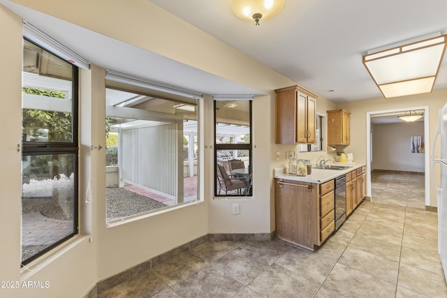 kitchen with dishwasher, light tile patterned floors, and sink