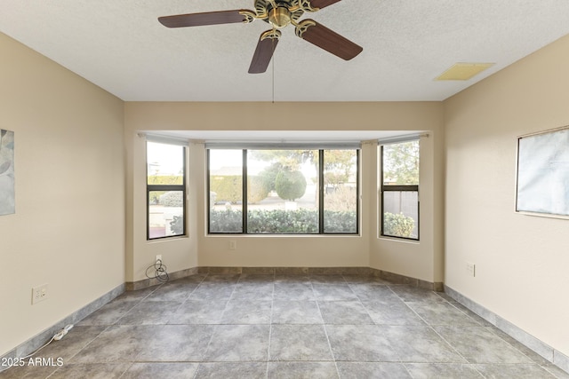 spare room with ceiling fan and a textured ceiling