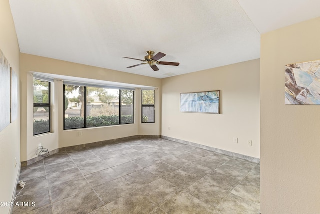 spare room featuring plenty of natural light and ceiling fan