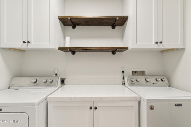 clothes washing area featuring cabinets and washer and clothes dryer