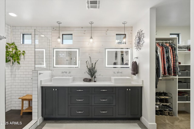 bathroom featuring vanity, tile walls, and walk in shower