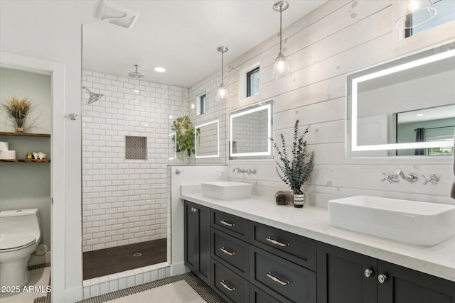 bathroom with vanity, tiled shower, tile patterned floors, and toilet