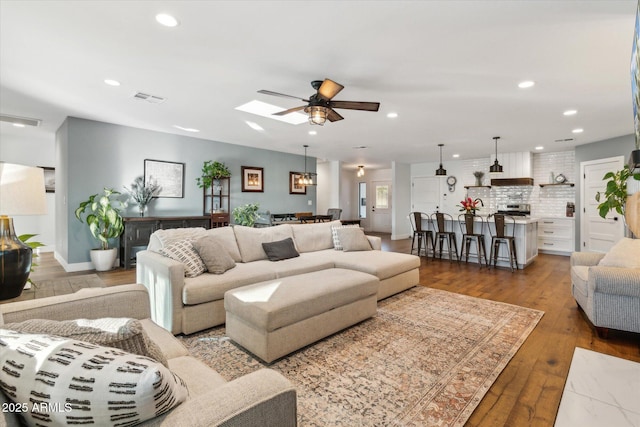 living room featuring dark hardwood / wood-style flooring and ceiling fan