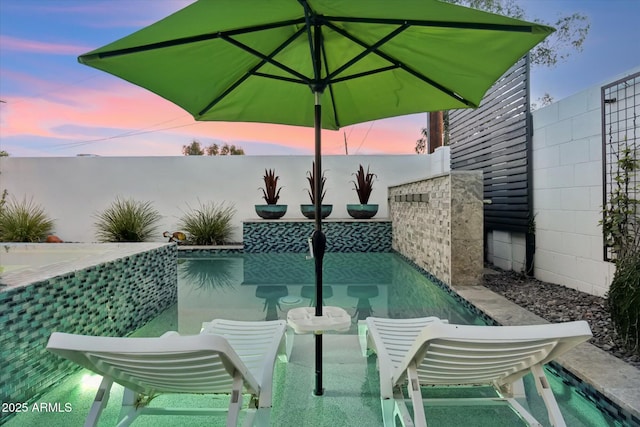 view of pool at dusk