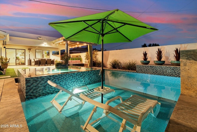 pool at dusk with an outdoor bar