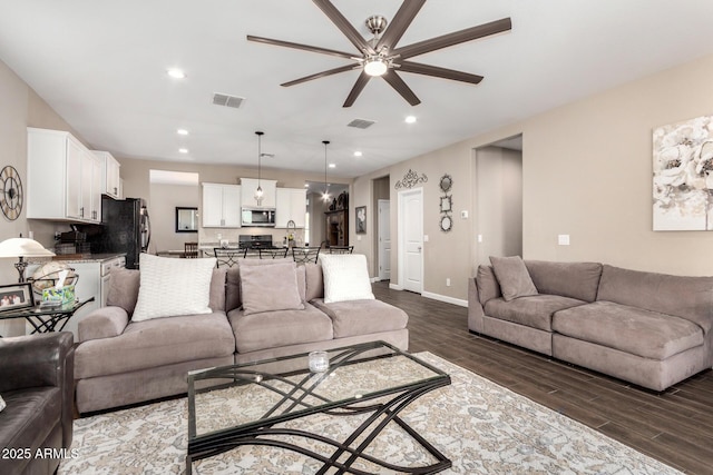 living room with visible vents, dark wood finished floors, and recessed lighting