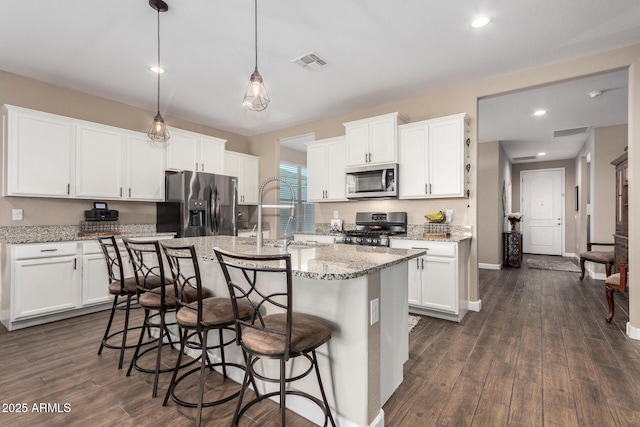 kitchen featuring dark wood-style floors, stainless steel appliances, a sink, and visible vents