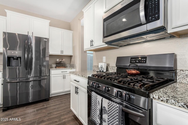 kitchen with appliances with stainless steel finishes, light stone countertops, white cabinetry, and dark wood-style floors