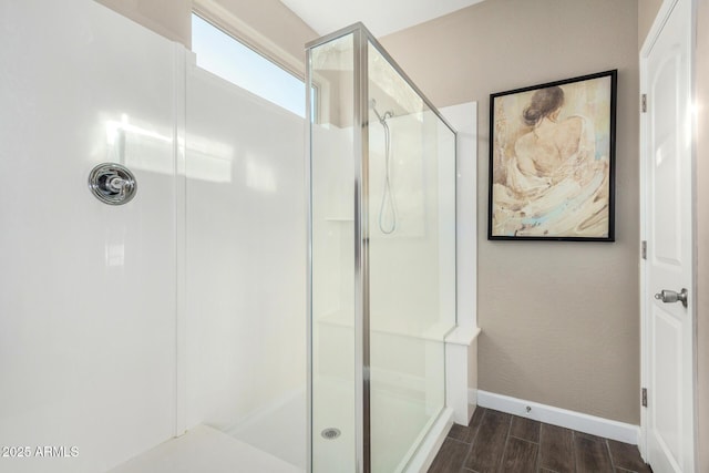 full bath featuring a stall shower, baseboards, and wood finish floors