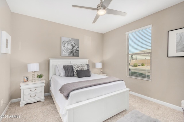 bedroom with a ceiling fan, light colored carpet, and baseboards