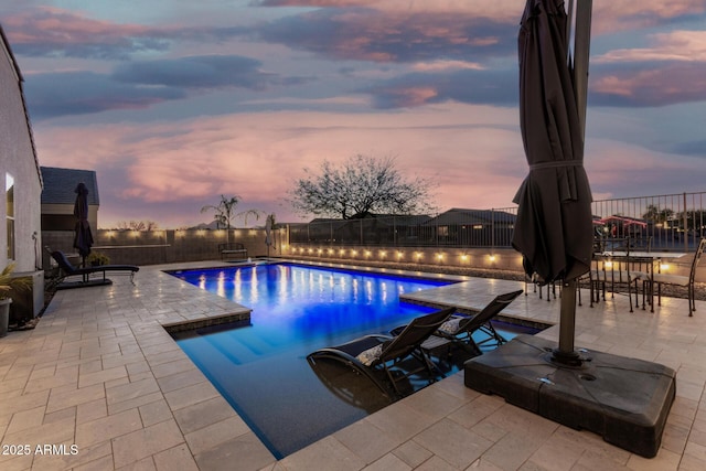 pool at dusk featuring a fenced in pool, a patio area, and a fenced backyard