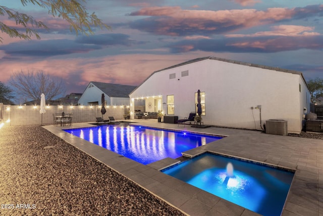 pool at dusk with a fenced in pool, a patio, central AC, a fenced backyard, and an outdoor living space