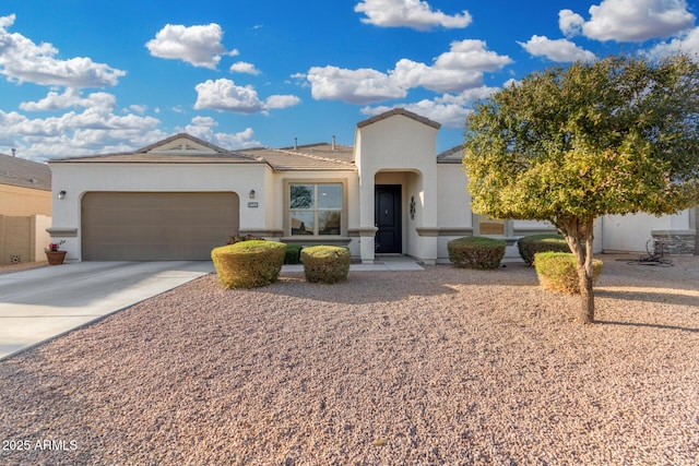 mediterranean / spanish home featuring an attached garage, a tile roof, concrete driveway, and stucco siding