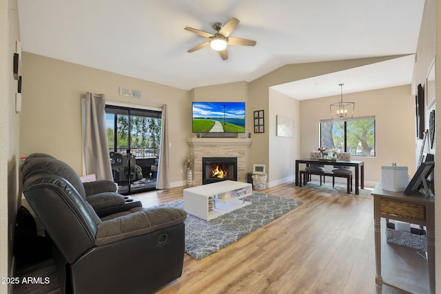 15050 N Thompson Peak Pkwy Unit 2072, Scottsdale, AZ 85260 - living room featuring ceiling fan, wood finished floors, lofted ceiling, a chandelier, and a glass covered fireplace