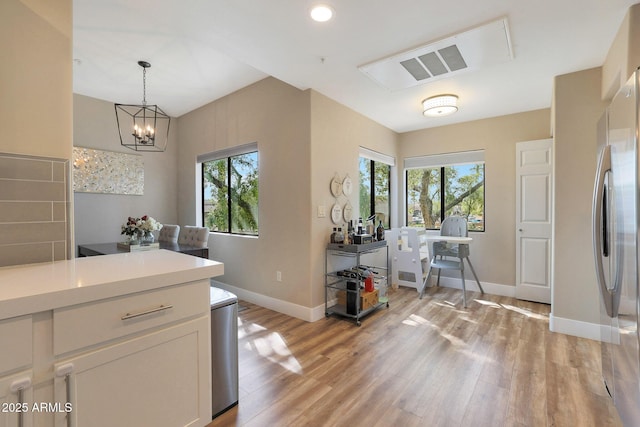 15050 N Thompson Peak Pkwy Unit 2072, Scottsdale, AZ 85260 - kitchen with freestanding refrigerator, light wood finished floors, baseboards, light countertops, and a chandelier