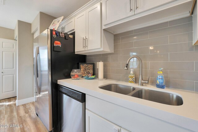 15050 N Thompson Peak Pkwy Unit 2072, Scottsdale, AZ 85260 - kitchen featuring a sink, appliances with stainless steel finishes, decorative backsplash, light countertops, and white cabinetry