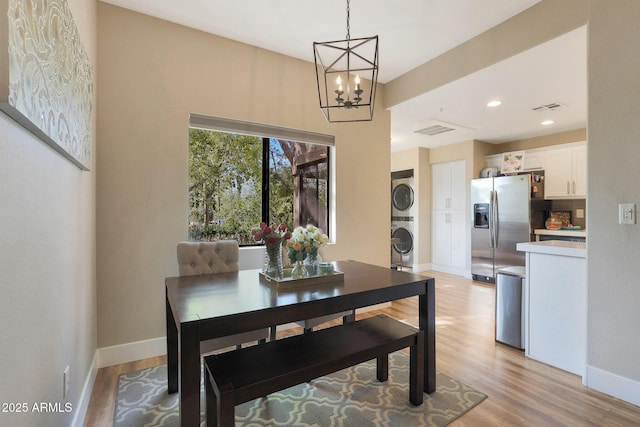 15050 N Thompson Peak Pkwy Unit 2072, Scottsdale, AZ 85260 - dining space featuring stacked washing machine and dryer, a chandelier, light wood-type flooring, baseboards, and recessed lighting