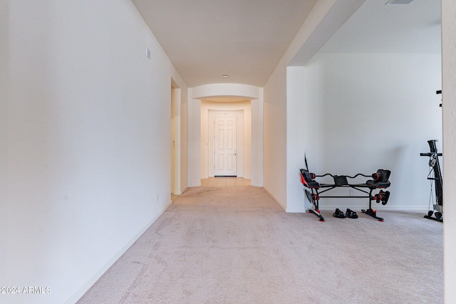 hall featuring light colored carpet and lofted ceiling