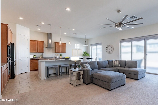 carpeted living room featuring ceiling fan with notable chandelier