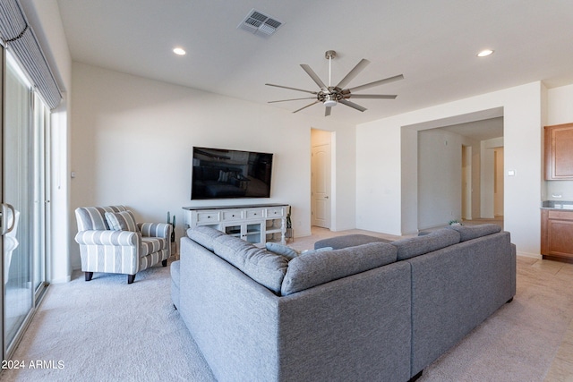 carpeted living room with ceiling fan