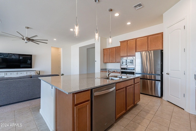 kitchen with sink, decorative light fixtures, a center island with sink, light tile patterned flooring, and appliances with stainless steel finishes